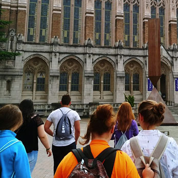 an image of students standing in front of a beautiful building in Europe