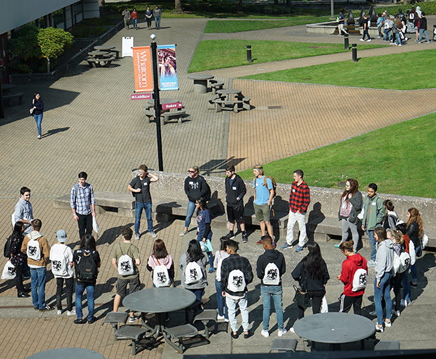 Students gather in a circle with their orientation guide