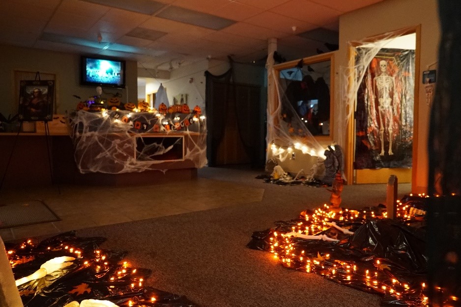An image of a halloween decorated classroom with orange lights, skeletons and spider webs