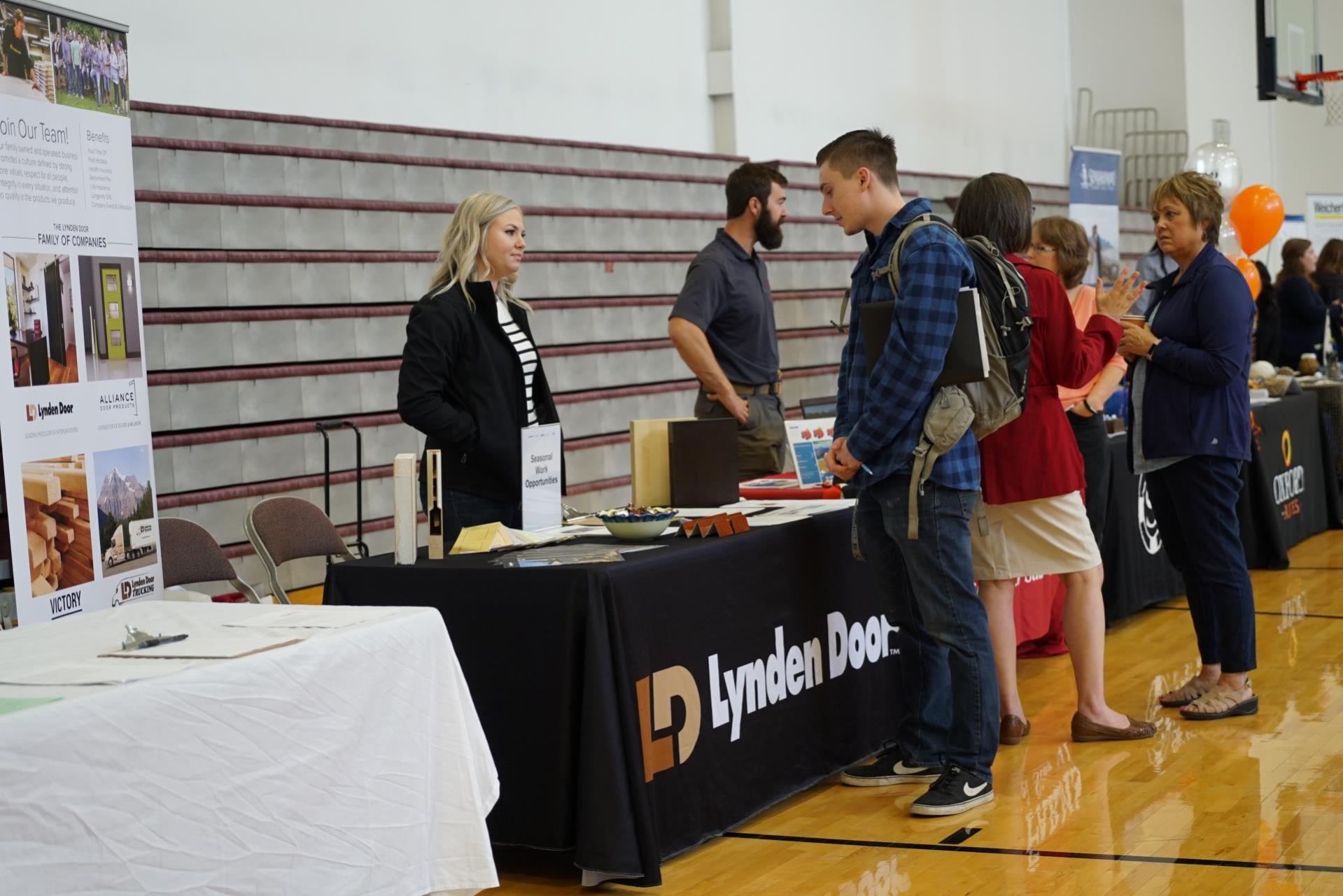 An image of a student standing at a job fair booth