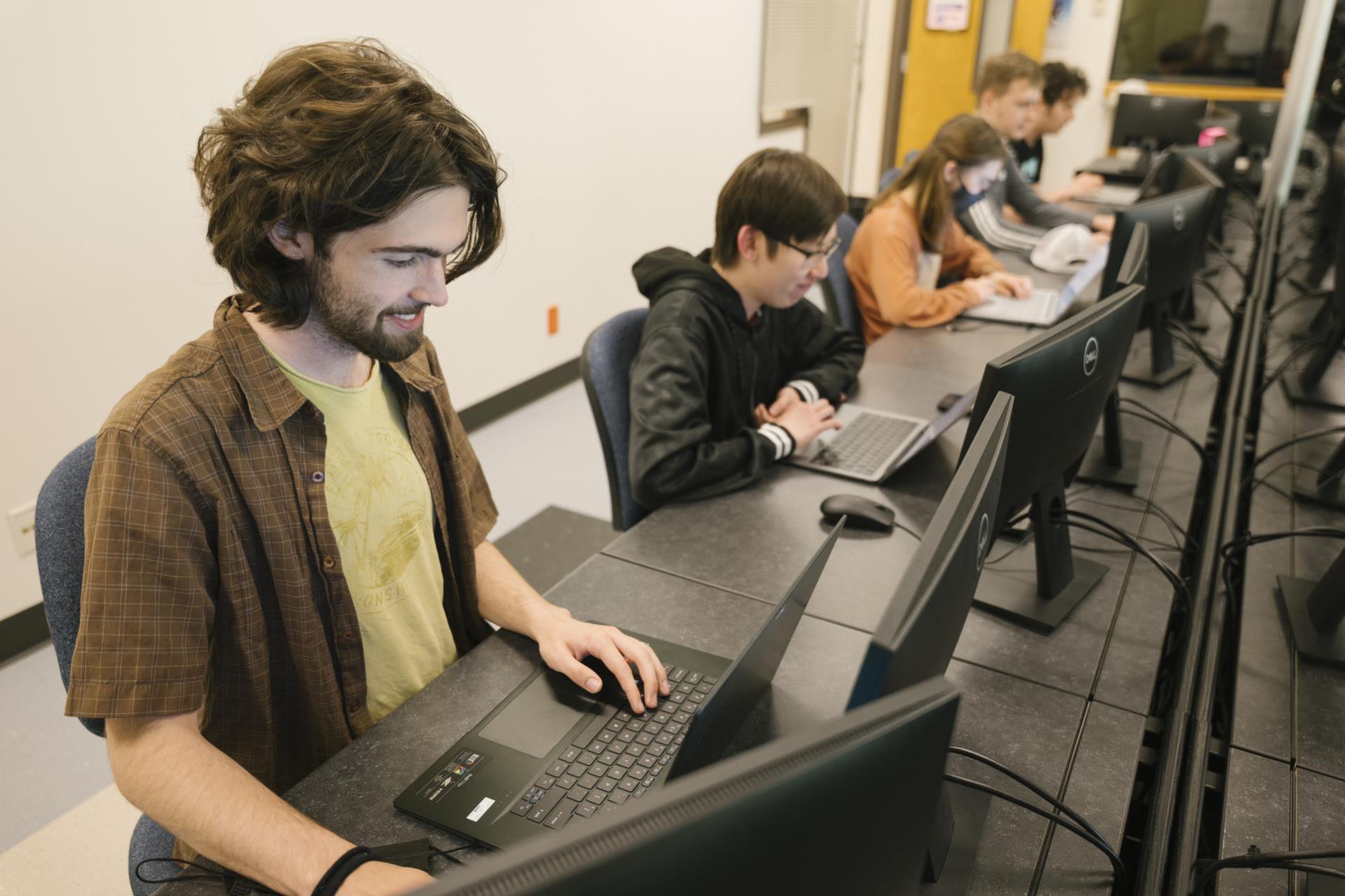 Software development students sit at their computers, working