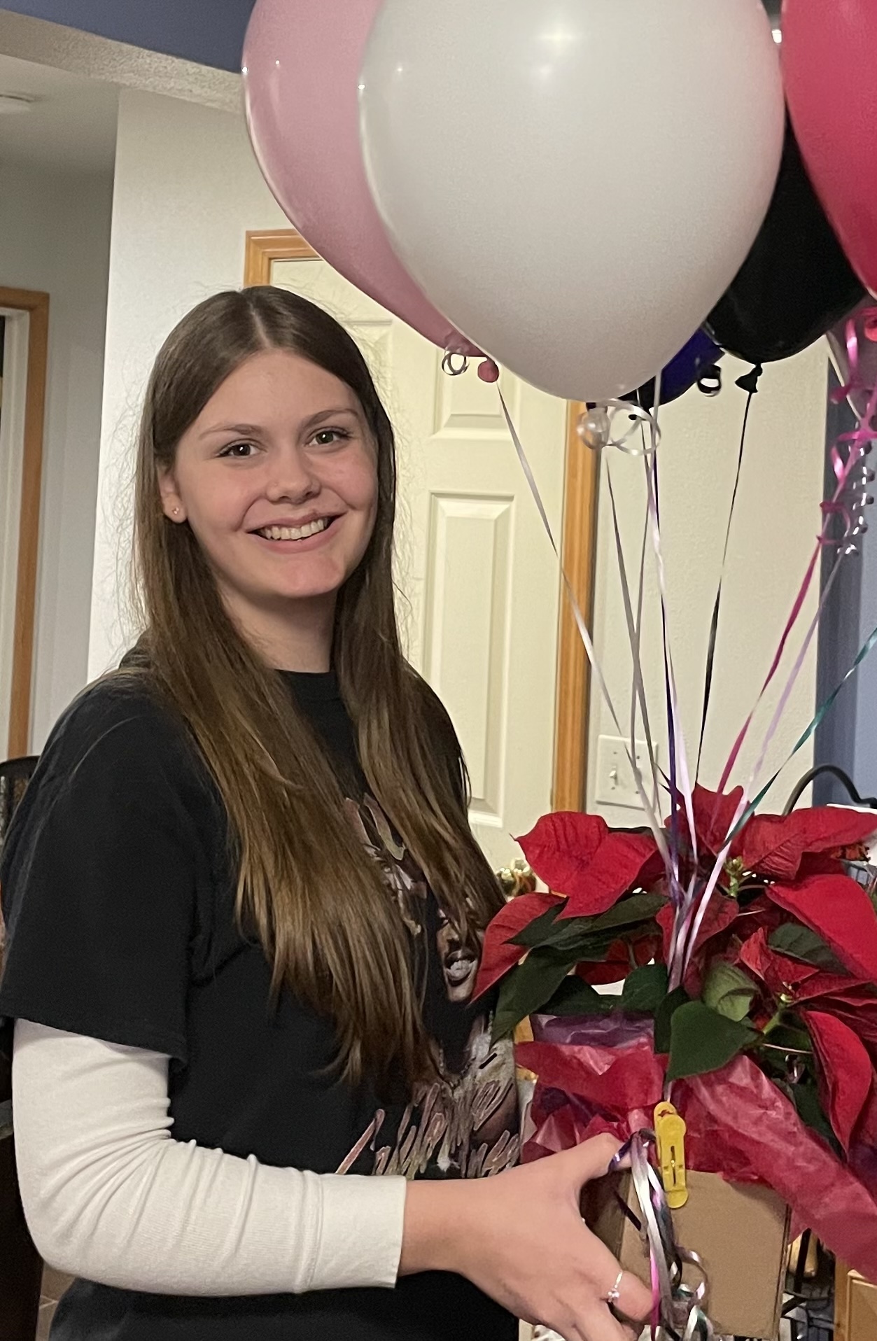 Mariah Brunn holding a bouquet of flowers and balloons