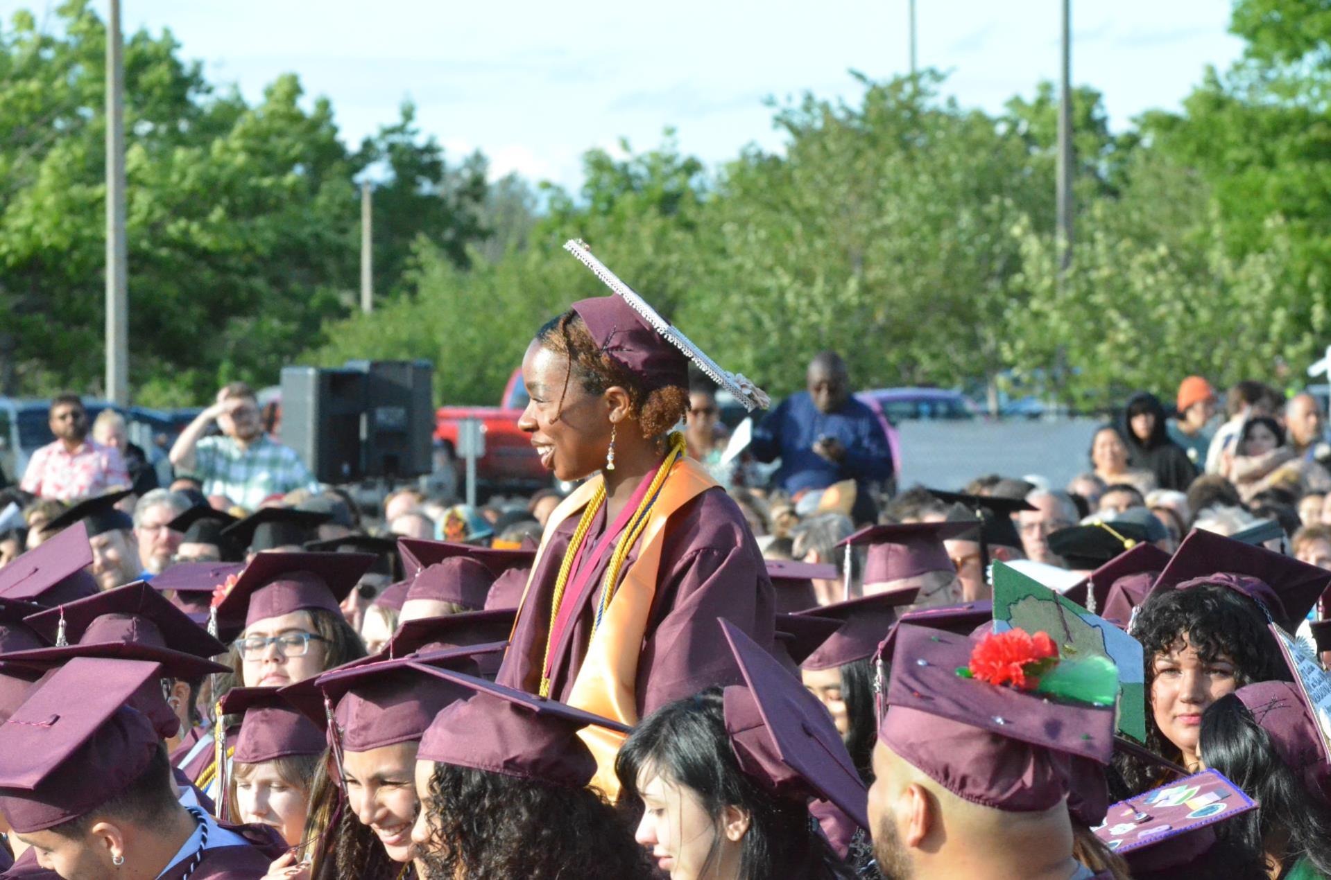An image of Cece Lovelace standing at commencement amongst other WCC student graduates