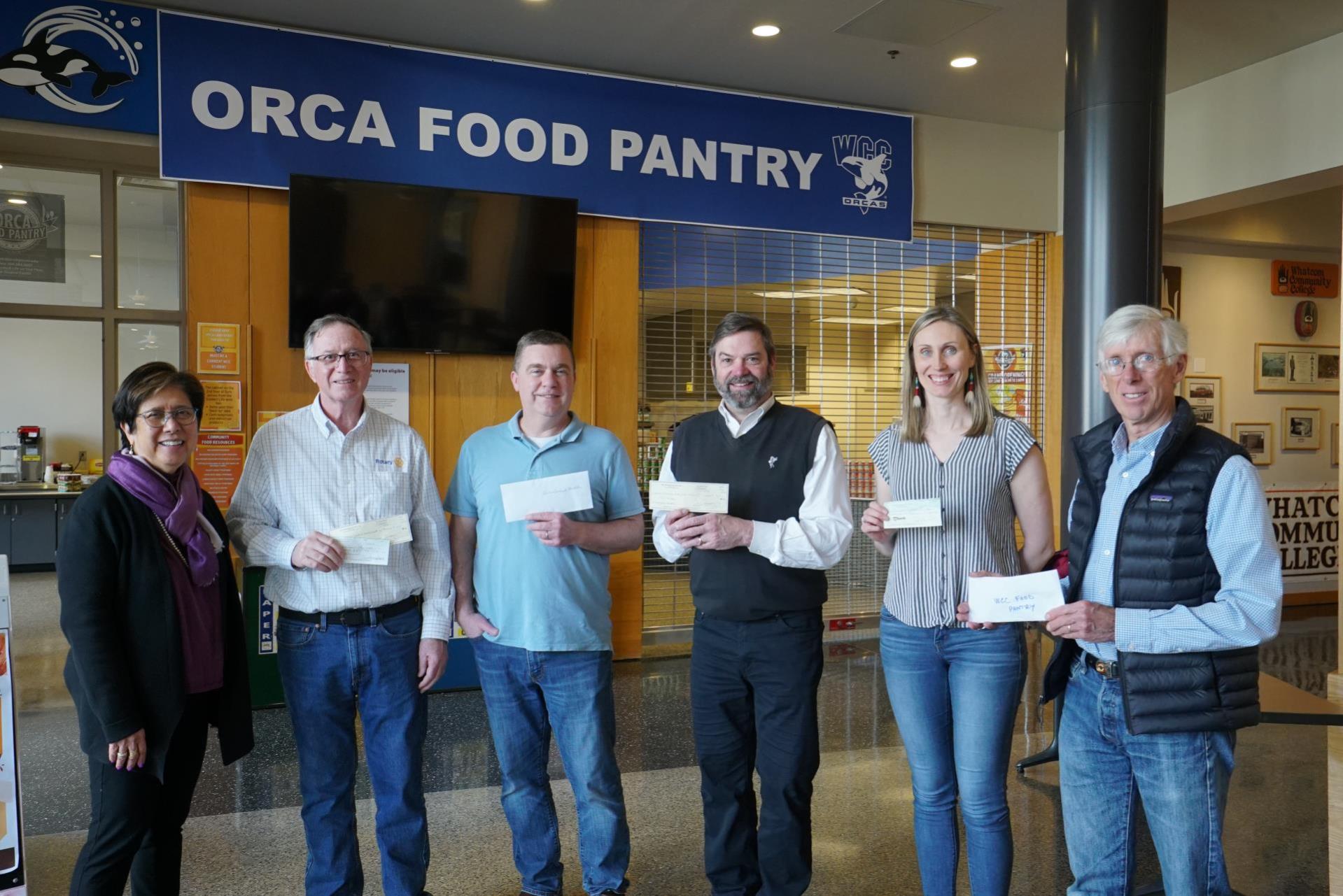 Rotary club members and President Kathi Hiyane-Brown pose infront of Orca Food Pantry