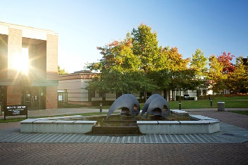Heiner Center with Gathering Fountain orca sculpture out front, sun reflecting off building windows